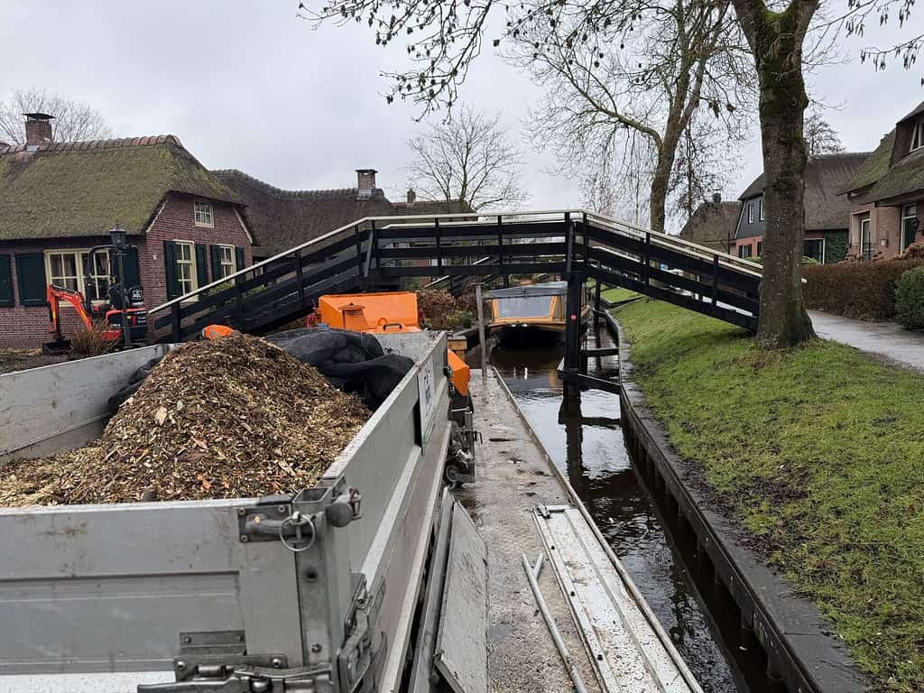 Werkboot met houtversnipperaar in de dorpsgracht van Giethoorn