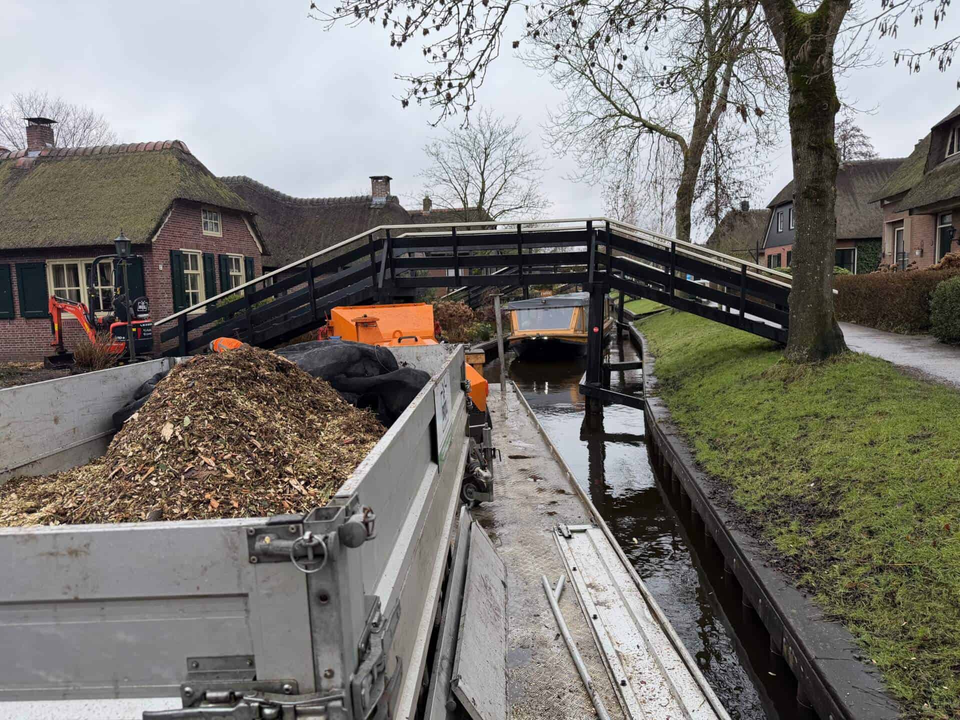 Werkboot met houtversnipperaar in de dorpsgracht van Giethoorn